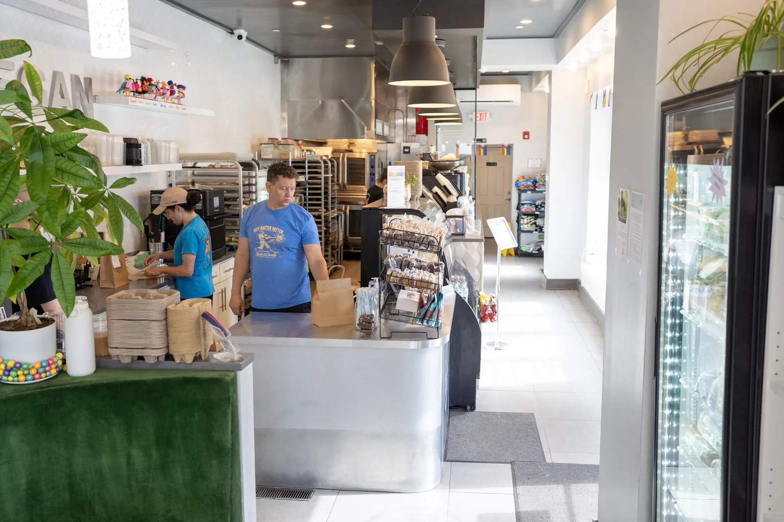 Staff working the counter with the bakery racks behind them