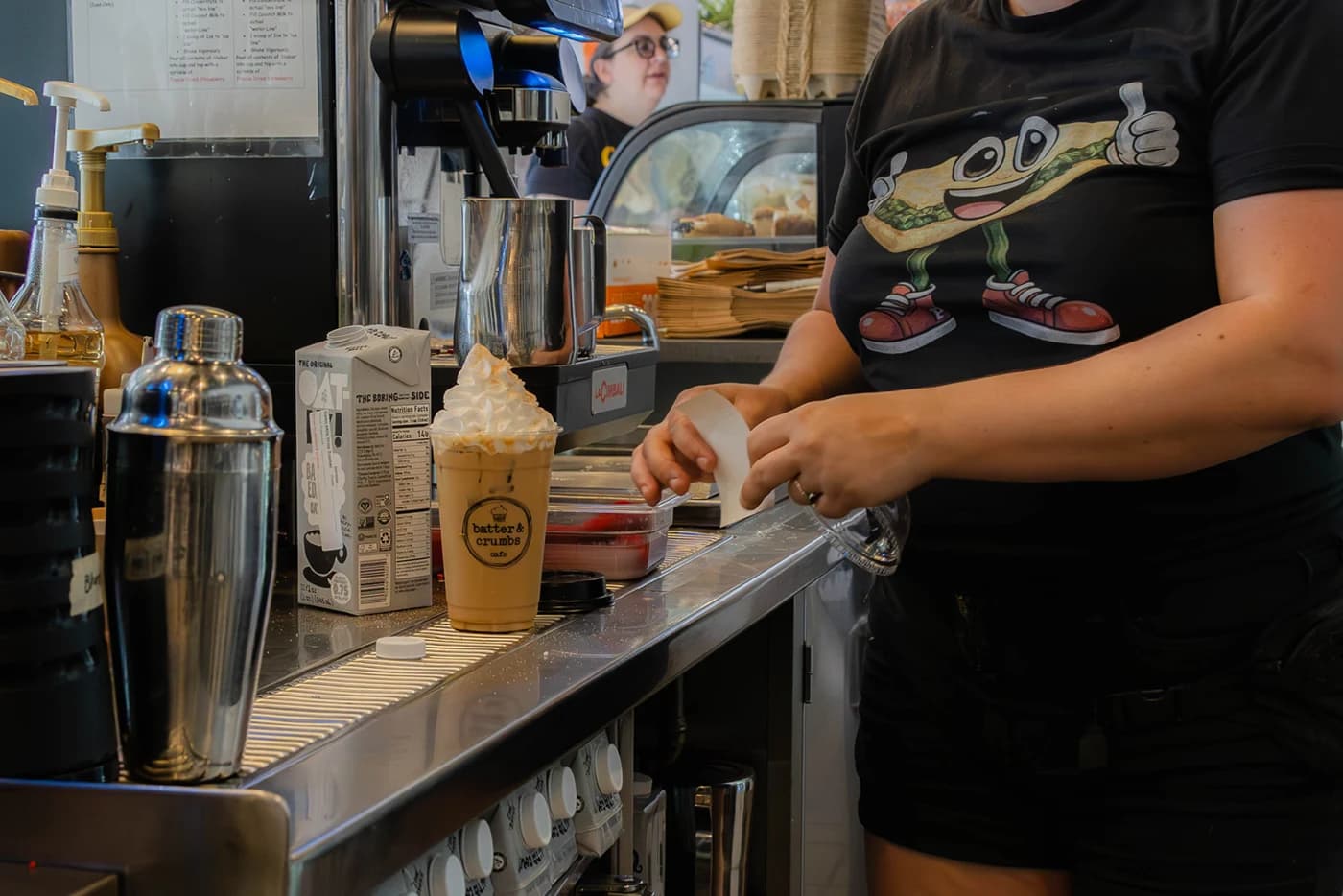 A barista finishing drinks behind the counter